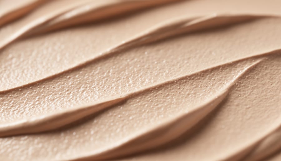 Macro close-up of foundation texture being blended on the back of a hand